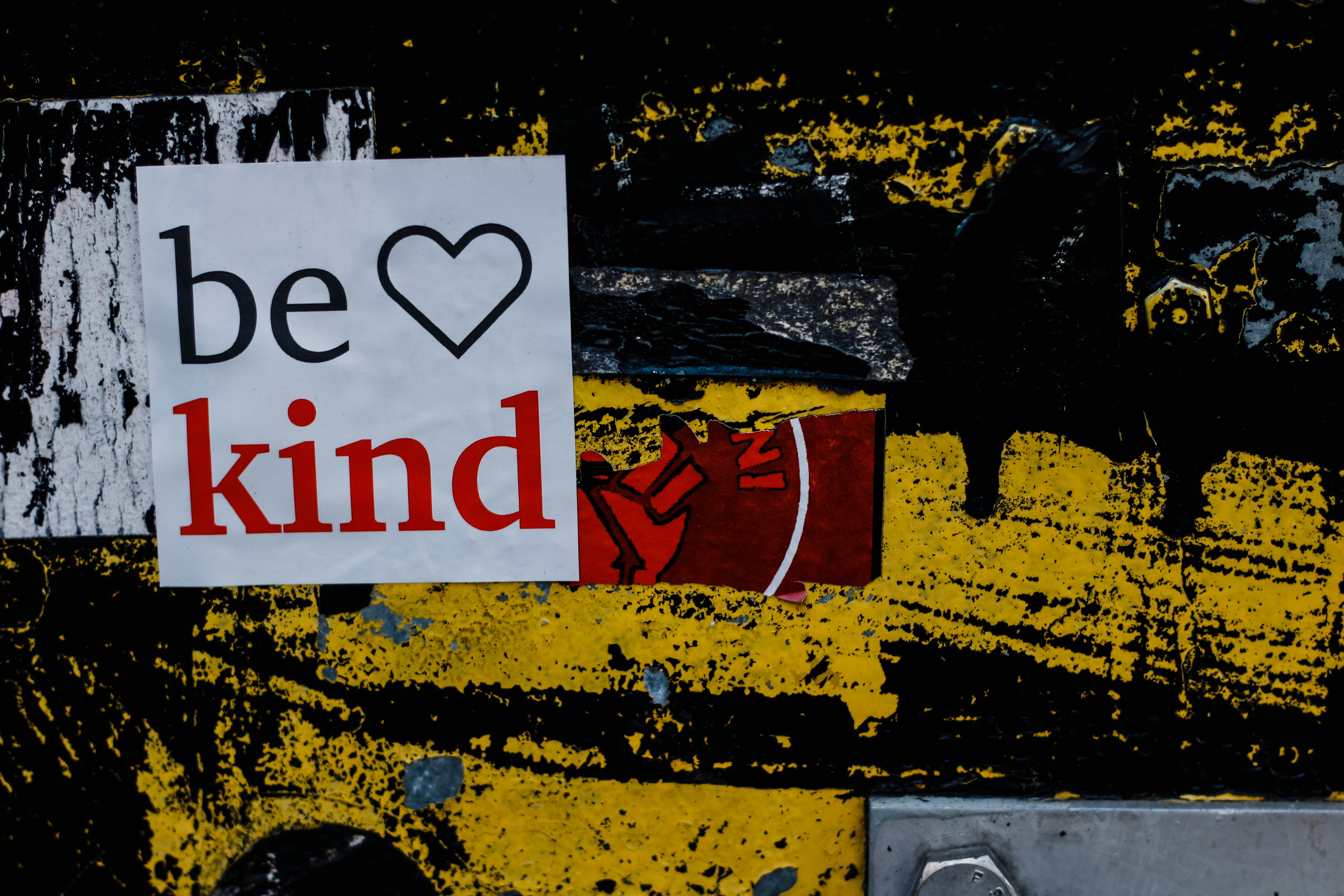 sticker on a wall that says: be kind